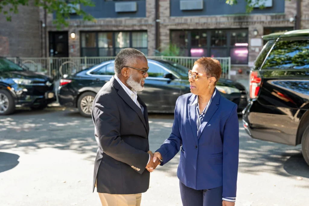 Emerita Adrienne Adams greeted by Hugh Hamilton